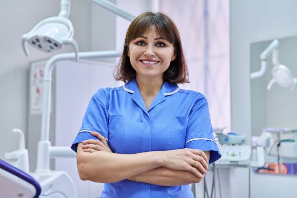 Portrait of smiling nurse looking at camera in dentistry. stock photo