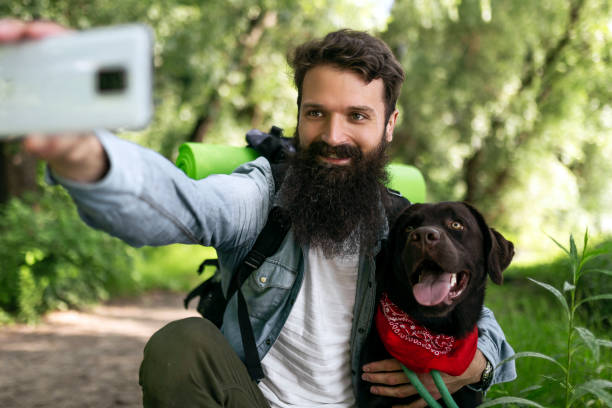 istock Hiker walking the dog through the woods making selfie 1400991122