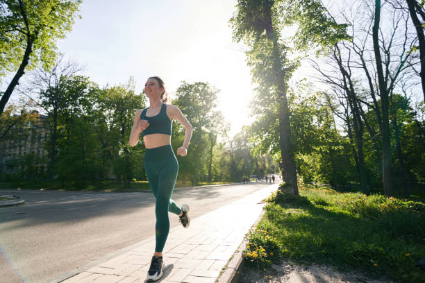 istock Slim female enjoying jogging during free time in park 1400993419