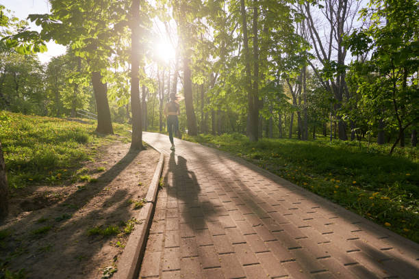 Slim woman going running in nature on sunny day