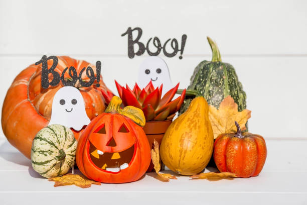 istock Happy Halloween! Pumpkin Jack on the table. Lantern with a carved smile and different attributes of the holiday on a light background.A copy of the place for the text. 1400994490
