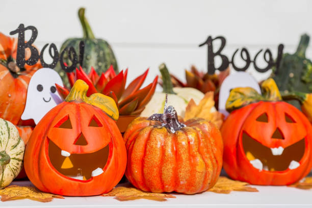 istock Happy Halloween! Pumpkin Jack on the table. Lantern with a carved smile and different attributes of the holiday on a light background.A copy of the place for the text. 1400994491