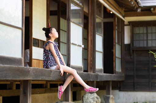 Girl sitting on the balcony of a Japanese house