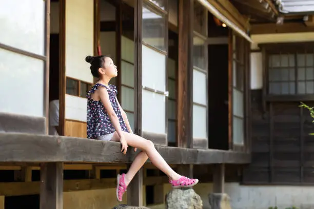 Photo of Girl sitting on the balcony of a Japanese house