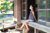 日本家屋のバルコニーに座っている少女