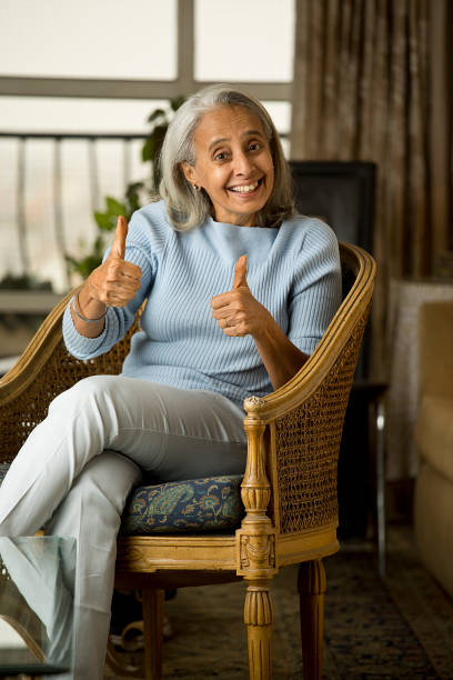 istock Cheerful old woman gesturing thumbs up at home 1400994827
