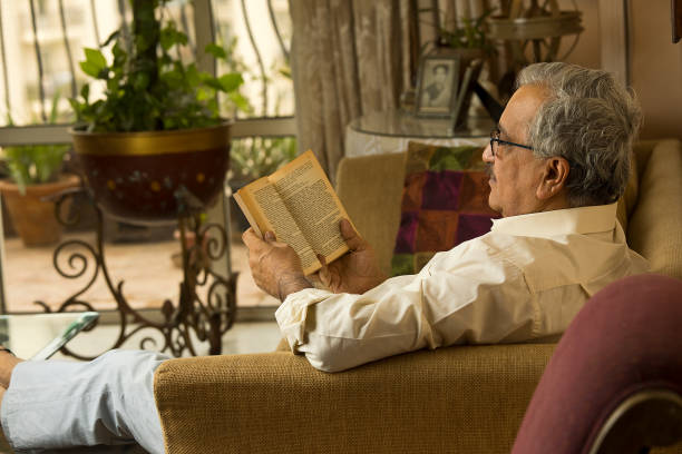 istock Man reading a book at home 1400995406