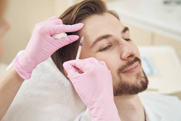 istock Relaxed male getting beauty injection in his forehead 1400996664