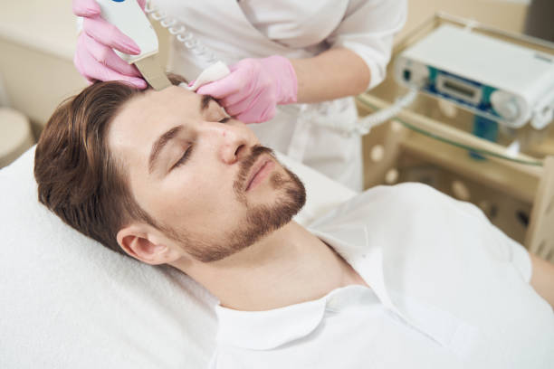 istock Cosmetologist conducting forehead ultrasonic cleaning with tool 1400996696