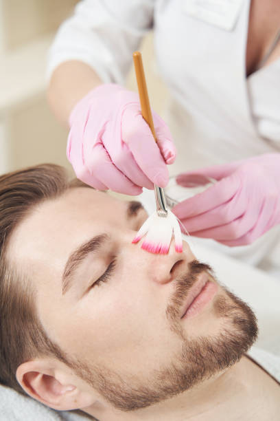 istock Beauty therapist covering man nose in peeling solution 1400996756