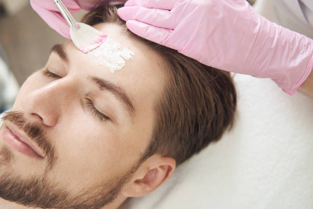 istock Beautician applying cream on forehead with brush 1400996764