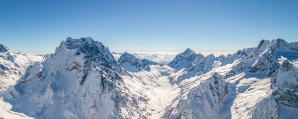 istock Mountain peaks covered in snow under a clear blue sky 1400996787
