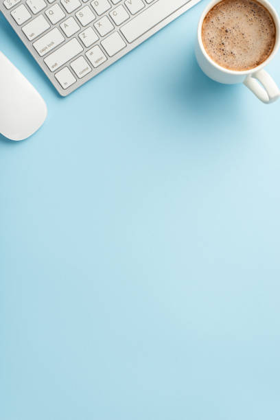 istock Business concept. Top view vertical photo of workstation keyboard computer mouse and cup of coffee on isolated pastel blue background with empty space 1400999548