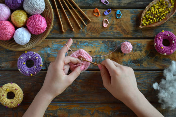 istock Making crochet amigurumi donuts. Toy for babies or trinket.  On the table threads, needles, hook, cotton yarn. Handmade gift. Income from hobby. DIY crafts concept. Step 1 - knit all details. 1401000868