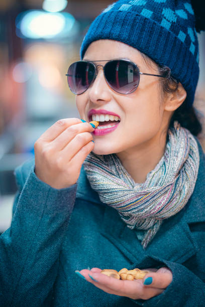 young woman eats peanuts. - peanut food snack healthy eating imagens e fotografias de stock