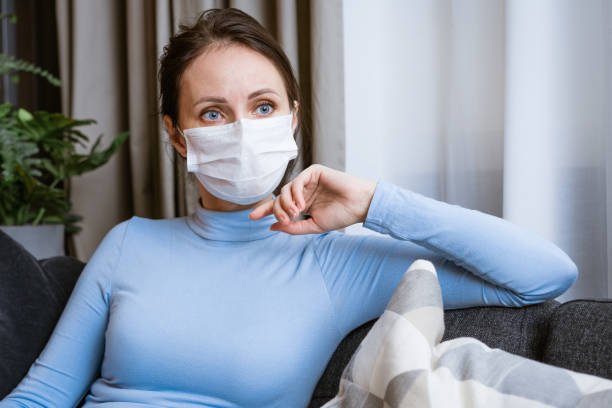 istock Woman in protective mask on the couch 1401003412