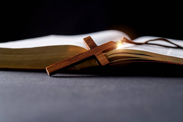 Wooden cross and bible on the table.