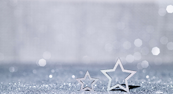 Christmas stars on shiny silver background.