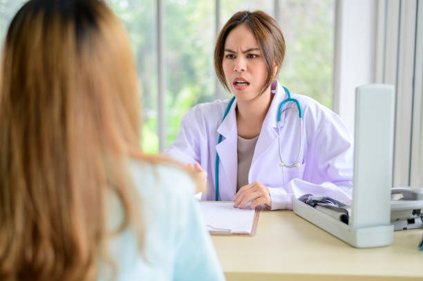 Conflict between a doctor and patient at the desk in hospital stock photo