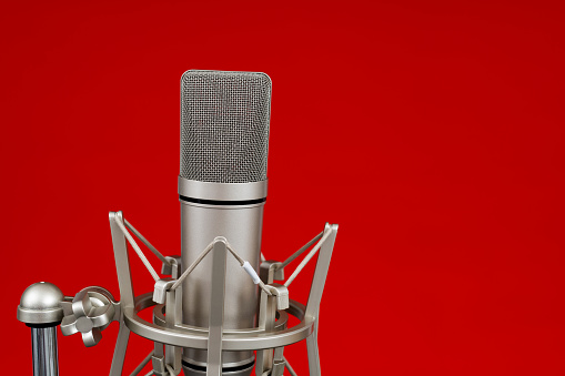 Condenser microphone on red background.