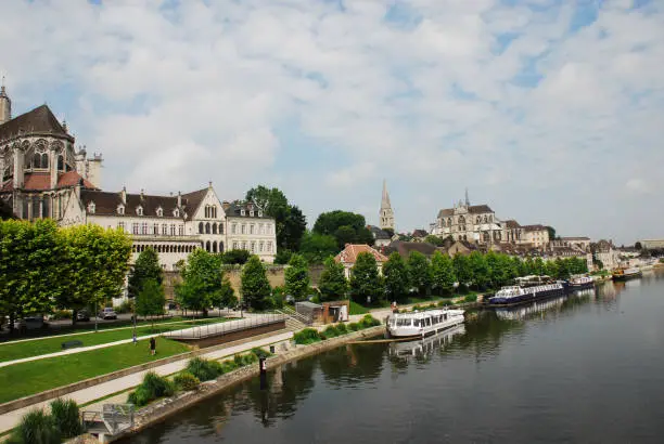 Panorama of the historically beautiful French city of Auxerre reflected in the Yonne river of Burgundy.  Please note, the very distant people are not recognizable.