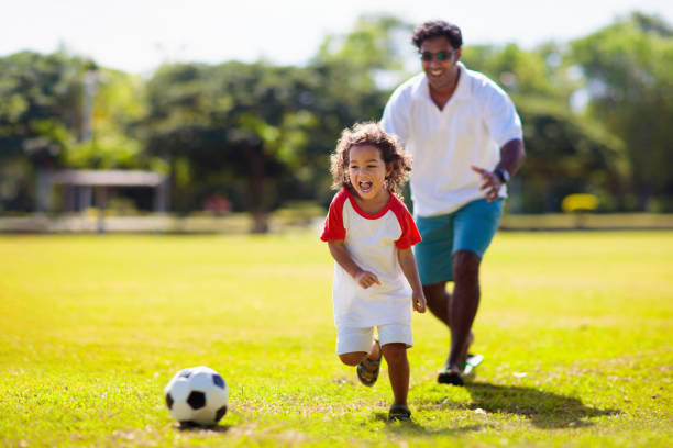 Father and son play football. Young active family. stock photo