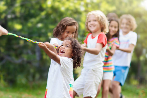 istock Kids play tug of war. Children pull rope. 1401008323