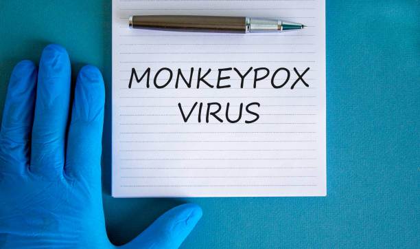 istock Monkeypox virus symbol. Concept words Monkeypox virus on white note. Doctor hand in blue glove with metallic pen. Medical mask. Medical and Monkeypox virus concept. Copy space. 1401009563