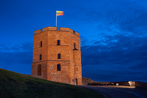 Gediminas' Tower with Lithuanian flag against the blue evening sky, Vilnius, Lithuania