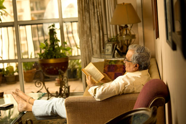 istock Man reading a book at home 1401010726