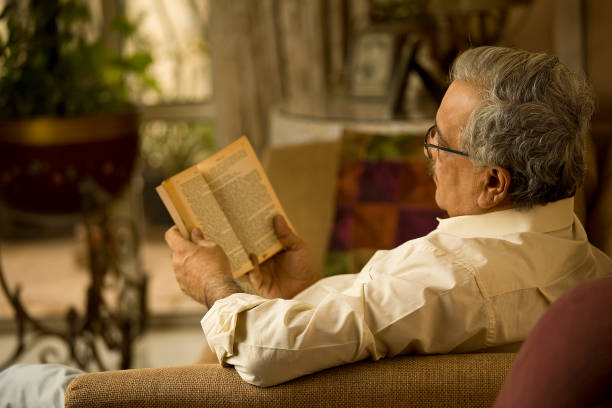 istock Man reading a book at home 1401010755
