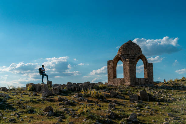 Backpacking man trekking in Dara Ruins in Mardin province. The young man visits the hill where the historical dome is located. Taken with a full-frame camera in sunny weather.