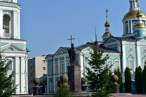 City Christian church with gilded domes, a bell tower and a monument.