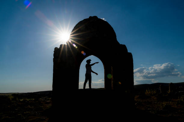 photo of man viewed with virtual reality simulator under the dome. Taken as a silhouette in reverse light. The man with open arms in the dome was shot with a full frame camera.