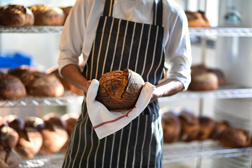 Baker holding sourdough bread