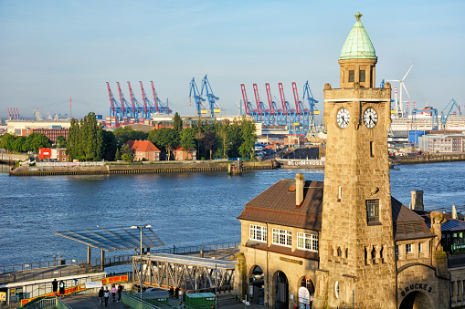 Panoramic aerial view over the rooftops of Hamburg, from the copper tower of Hauptkirche Sankt Michaelis, St Michael’s Church, past the high rises of St. Pauli to the busy cranes of the Port of Hamburg and blue waters of the Elbe, Germany.