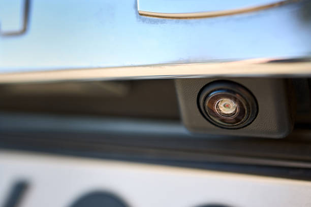 istock Car rear view camera parking sensor accessory reverse back new vehicle spycam with waterdrops. Luxury car rear view camera close up for parking assistance. Concept of safety car driving while parking 1401016043