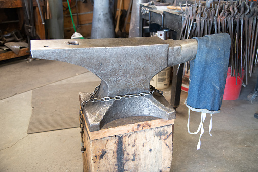Blacksmith anvil with blacksmith tools in background in western USA.