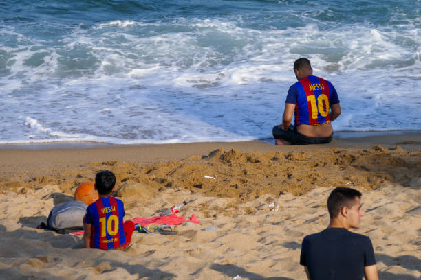 Dad and son with Leo Messi tshirt on the beach stock photo