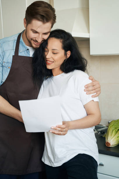 istock Happy young couple perusing business documentation at home 1401020693