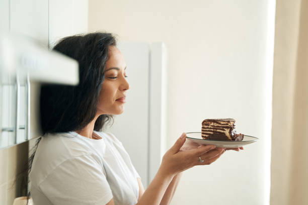 istock Pleased woman seated in kitchen looking at dessert before her 1401020736