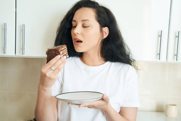 istock Hungry lady eating tasty dessert in kitchen 1401020738