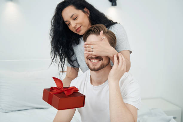 istock Romantic woman presenting gift to beloved person 1401020828
