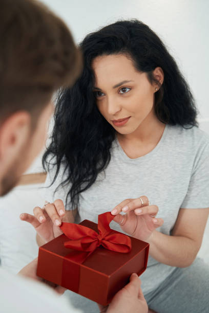 istock Young woman opening gift from beloved person 1401020829