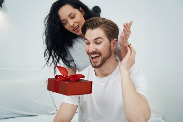 istock Joyful male getting gift from his romantic partner 1401020831