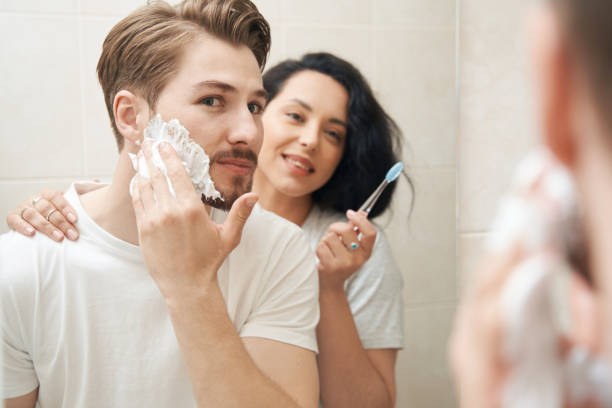 istock Young family couple standing before bathroom mirror 1401021028