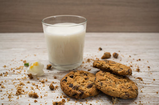 Cookies and glass of milk on wooden table