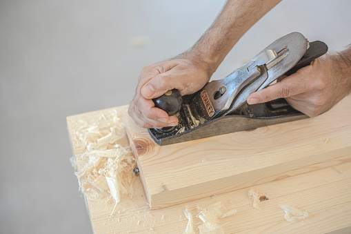 Traditional, manual planer for hand planing raw wood used by a carpenter