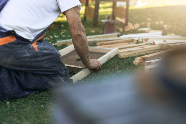 istock man kneeling on his back assembling a wooden structure in the garden 1401023746