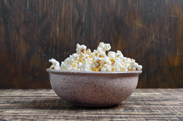 istock Fresh popcorn in a bowl on a wooden background. Rustic style. 1401024445